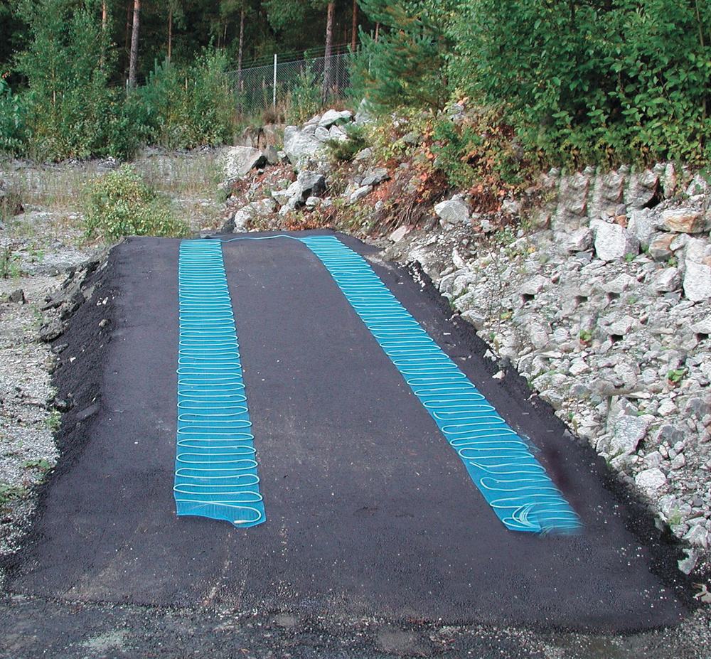 Alee in constructie, cu doua fasii de covoras de degivrare asezate pe urmele de roti, inainte de turnarea stratului de uzura