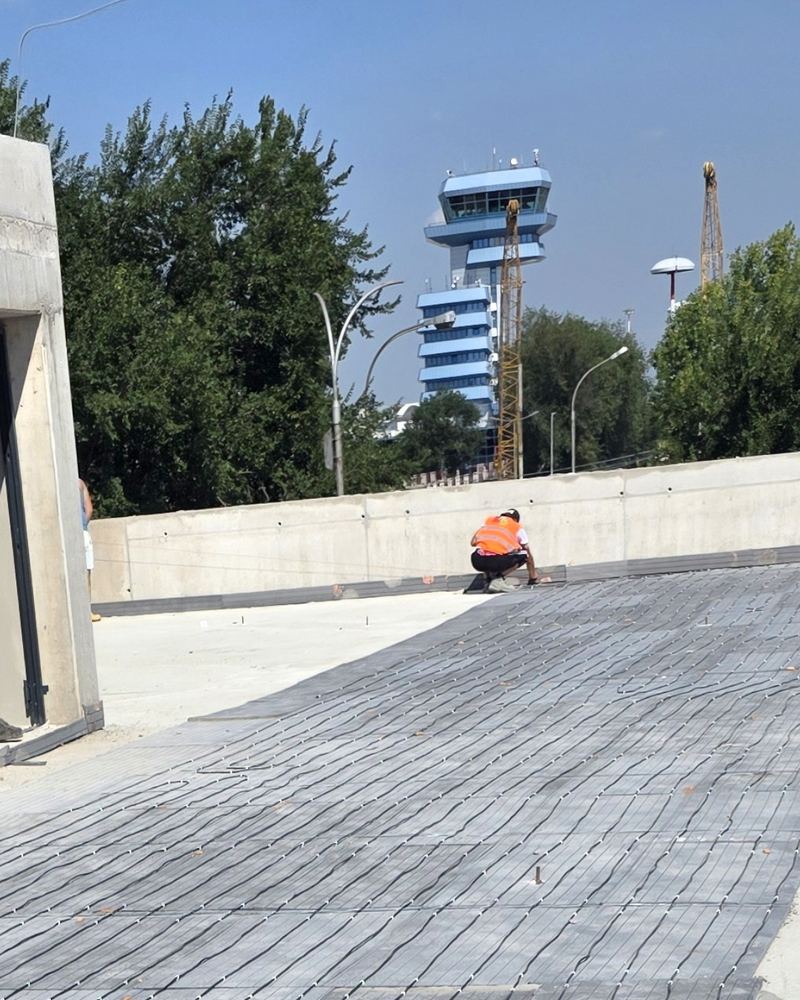Rampa parcarii de la Aeroportul Otopeni, cu cablul de degivrare montat, si turnul de control in fundal